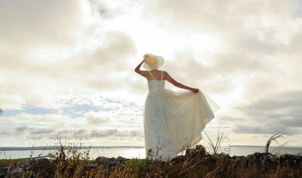 海を見下ろす白いドレスを着た女性の風景写真